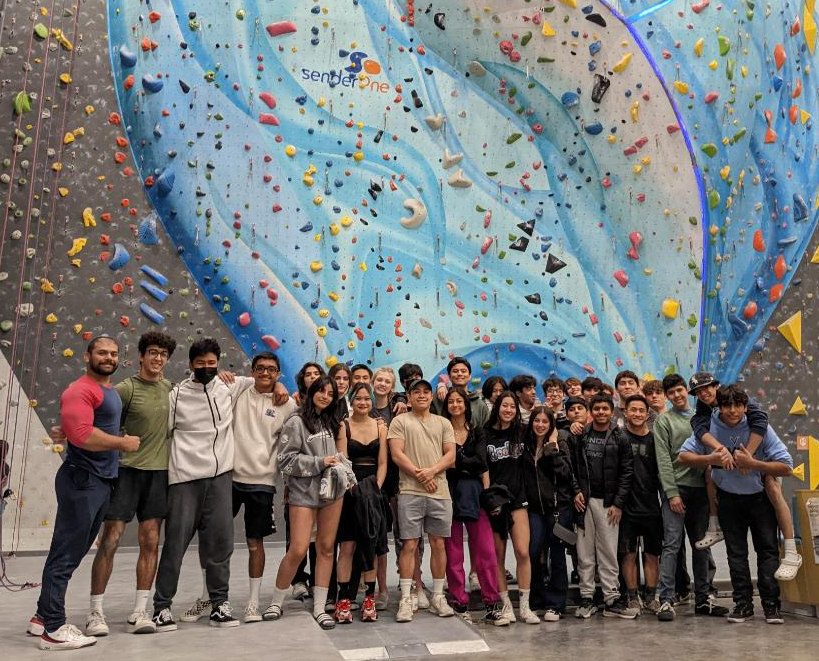 A group of people posing for a photo in front of a wall

Description automatically generated with medium confidence