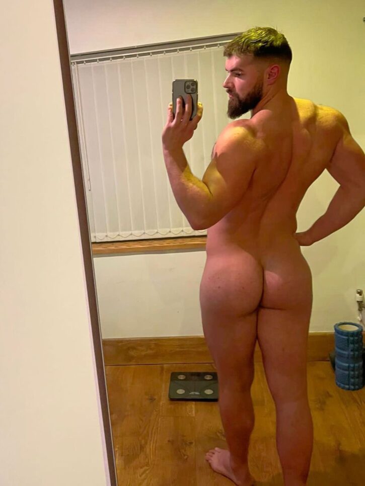 alpha bayton standing in the mirror showing off his muscled back and bubble butt in an iphone selfie