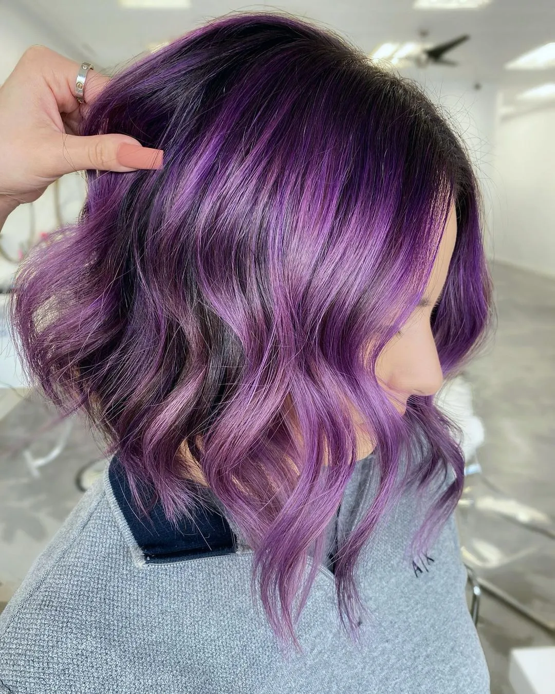 Side view of  lady rocking the purple color hair