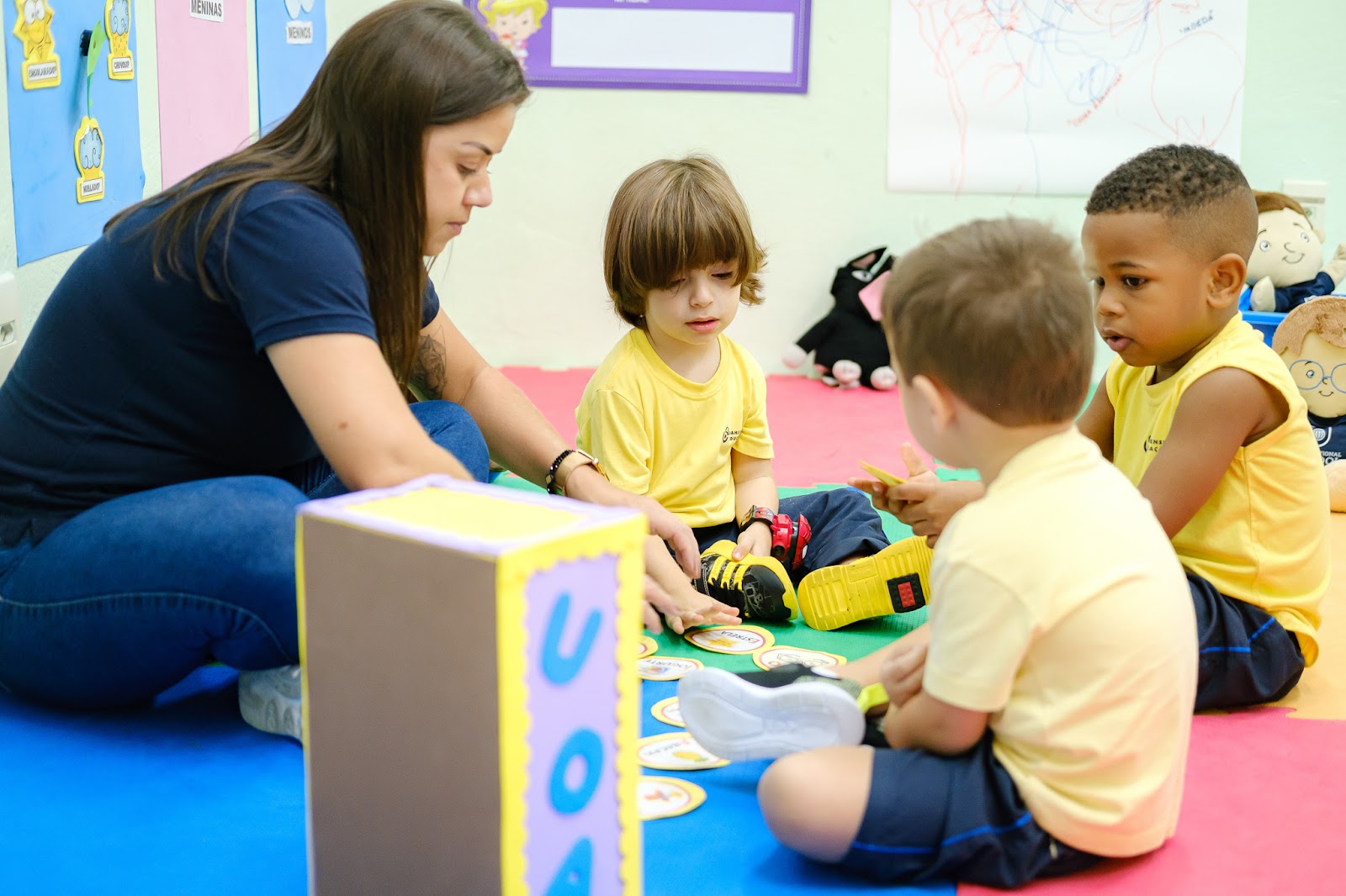 professora ensinando e brincando com alunos da Educação Infantil