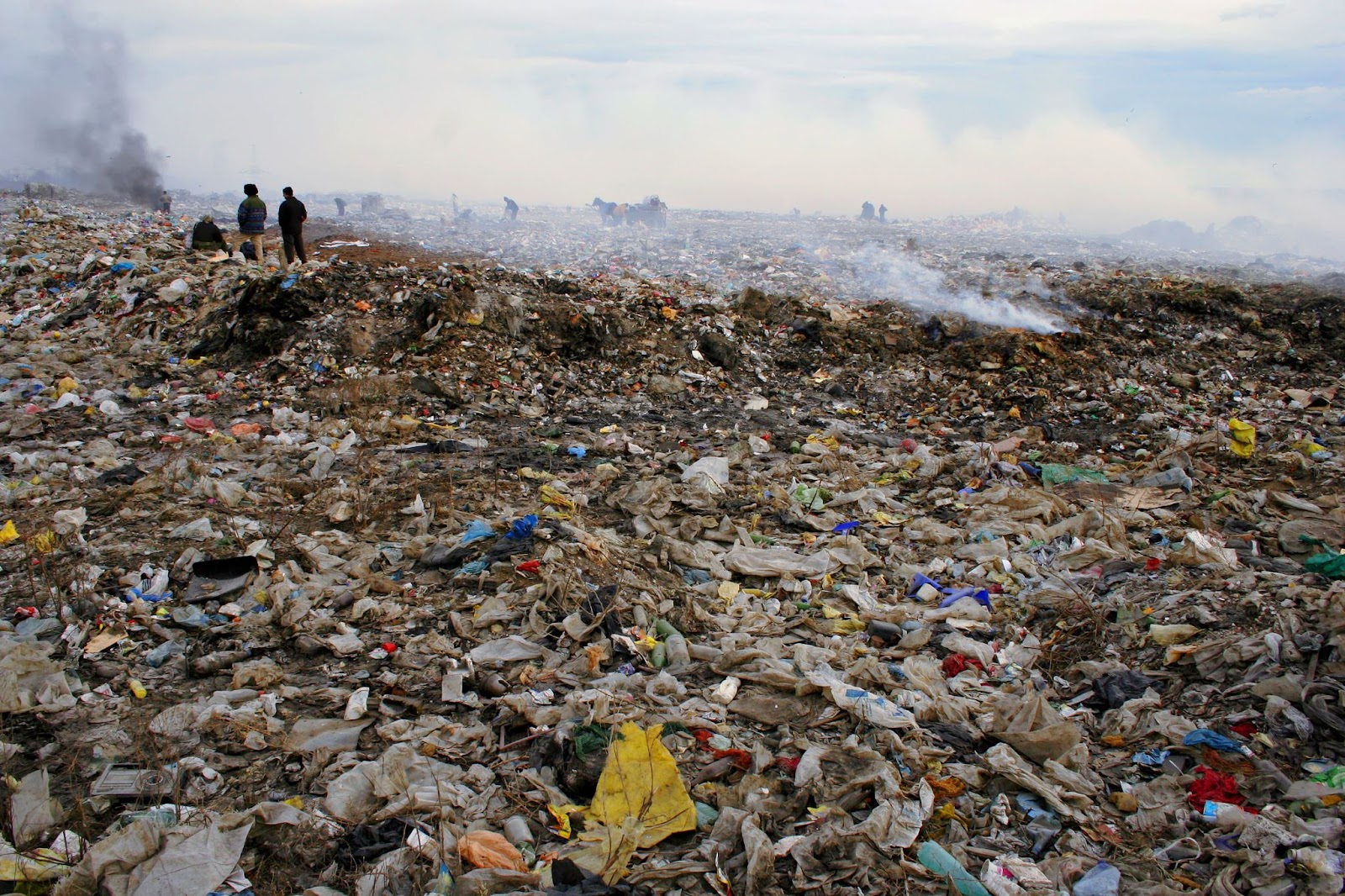 Piles of electronic waste filled with dark smoke in the air