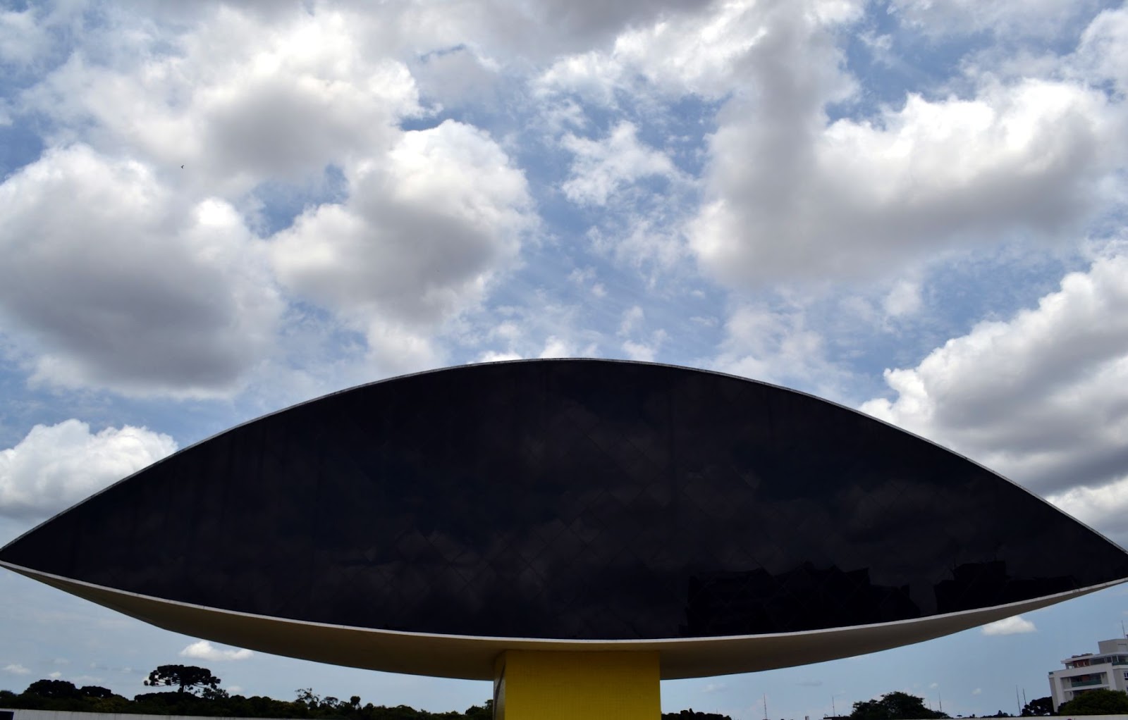 Foto de metade da fachada do Museu Oscar Niemeyer em Curitiba, mostrando apenas um lado da arquitetura em formato de olho.
