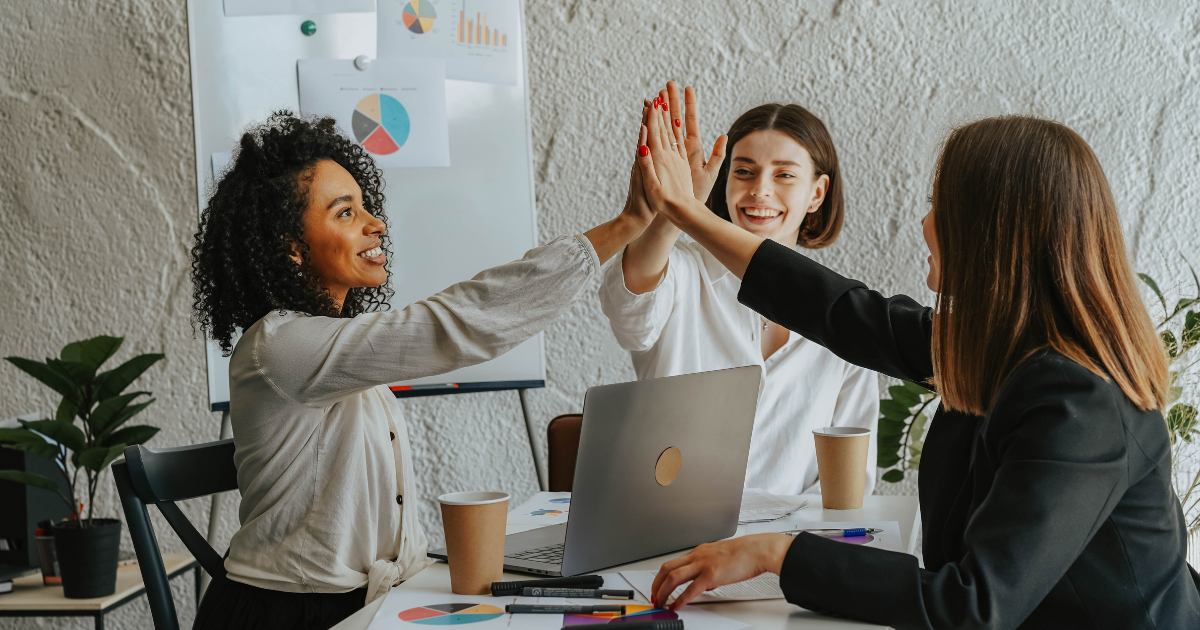 Team members high-fiving during a successful agile coaching session.