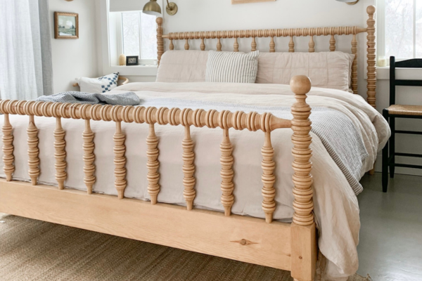 Spindle bed frame with mattress, blankets and pillows.