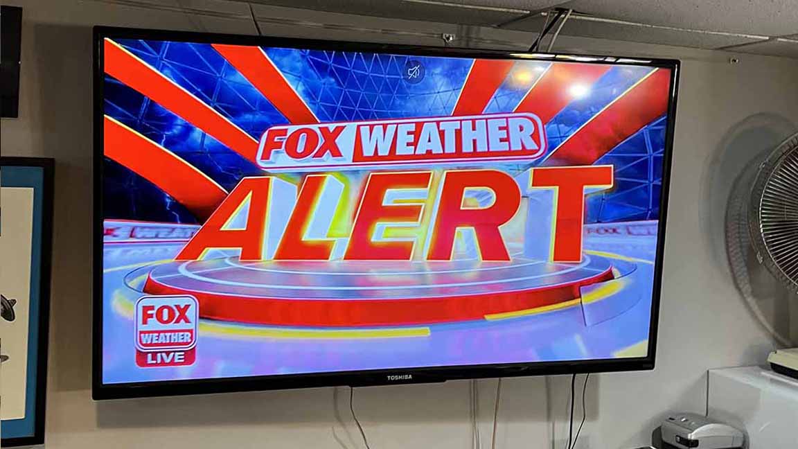 TV SCREEN: FOX WEATHER ALERT FOX WEATHER LIVE, glowing red and yellow with red rays emanating pure panic