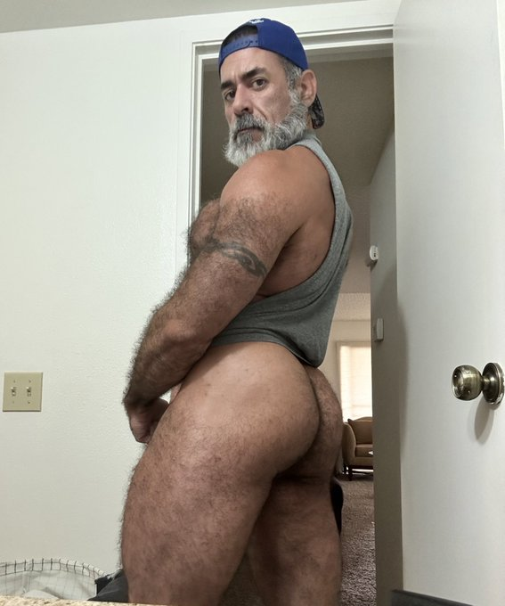 Lawson James wearing a grey tank top and for a selfie while showing off his hairy ass and legs