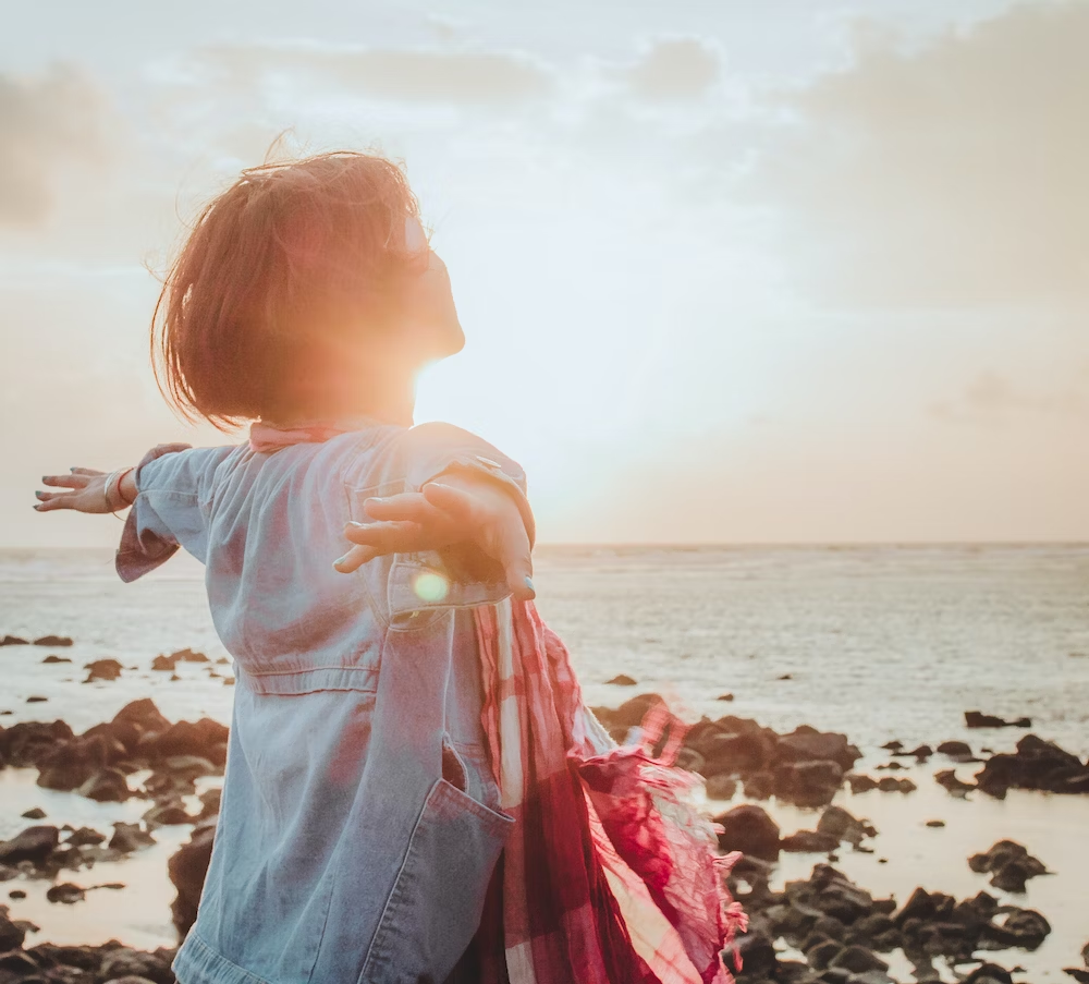 Girl Looking To The Sun With Arms Out Wide