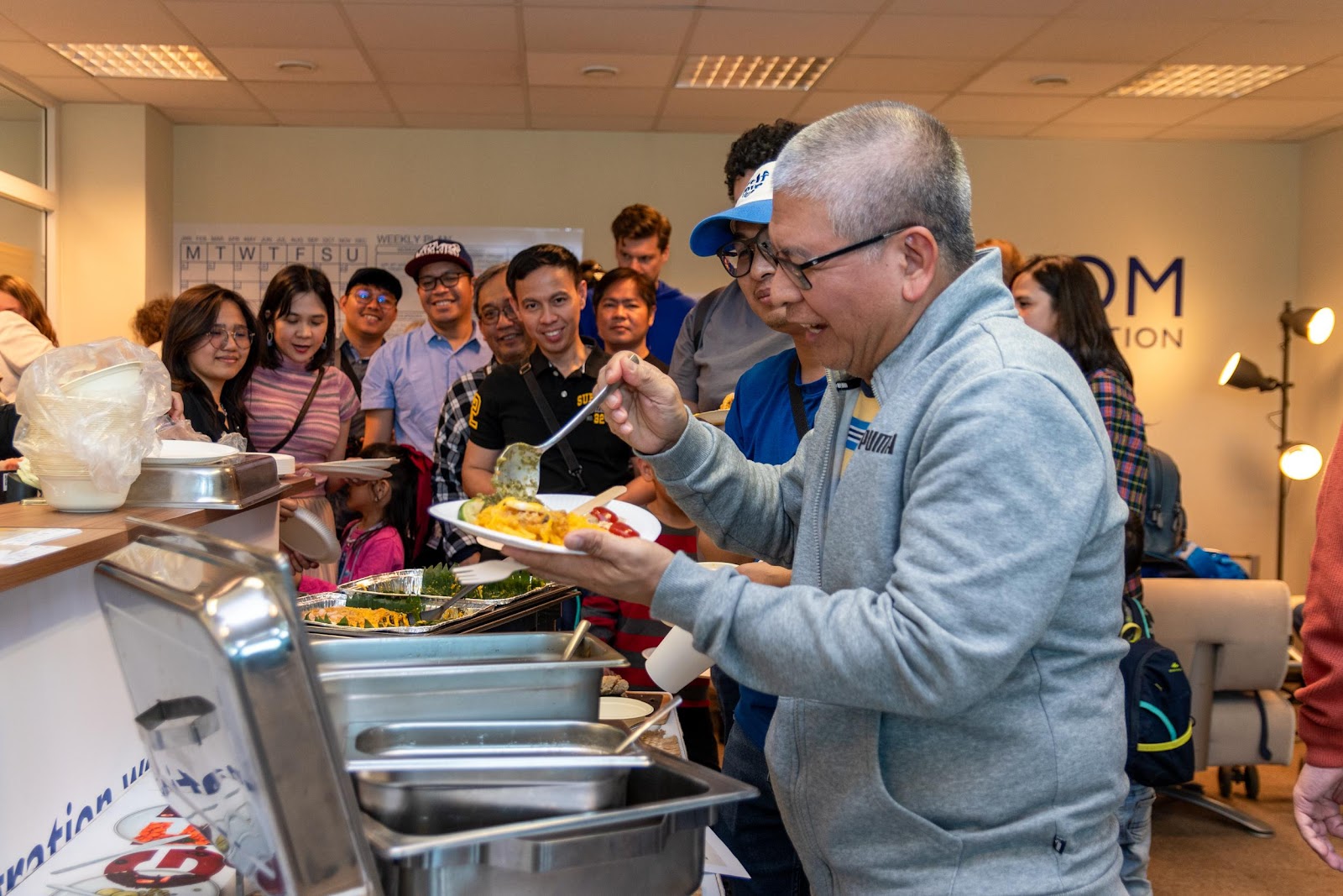 A person holding a plate of foodDescription automatically generated