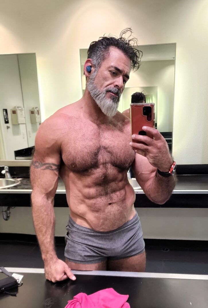 Lawson James taking a selfie at the gym wearing grey boxer briefs in front of the mirror