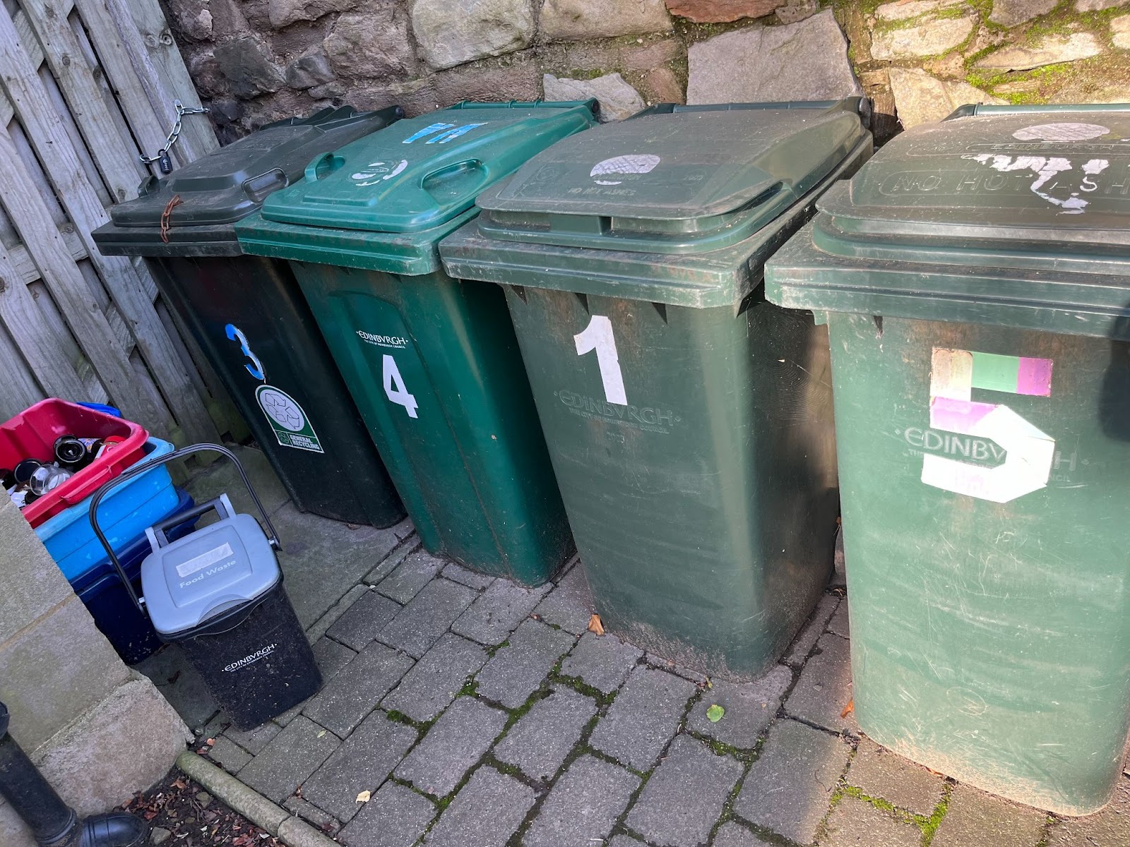 three types of bins standing in front of a house