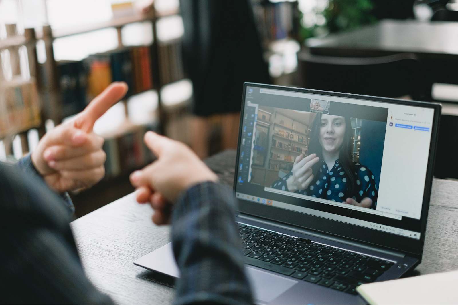 An image of two people in a video call doing sign language.
