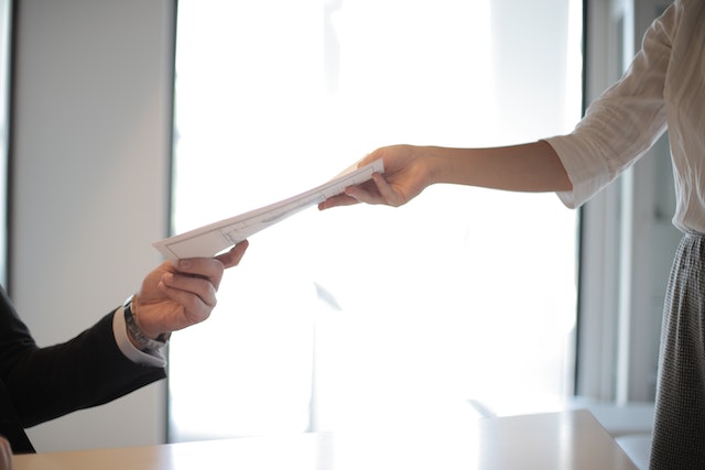 Two hands exchanging a lease rental agreement