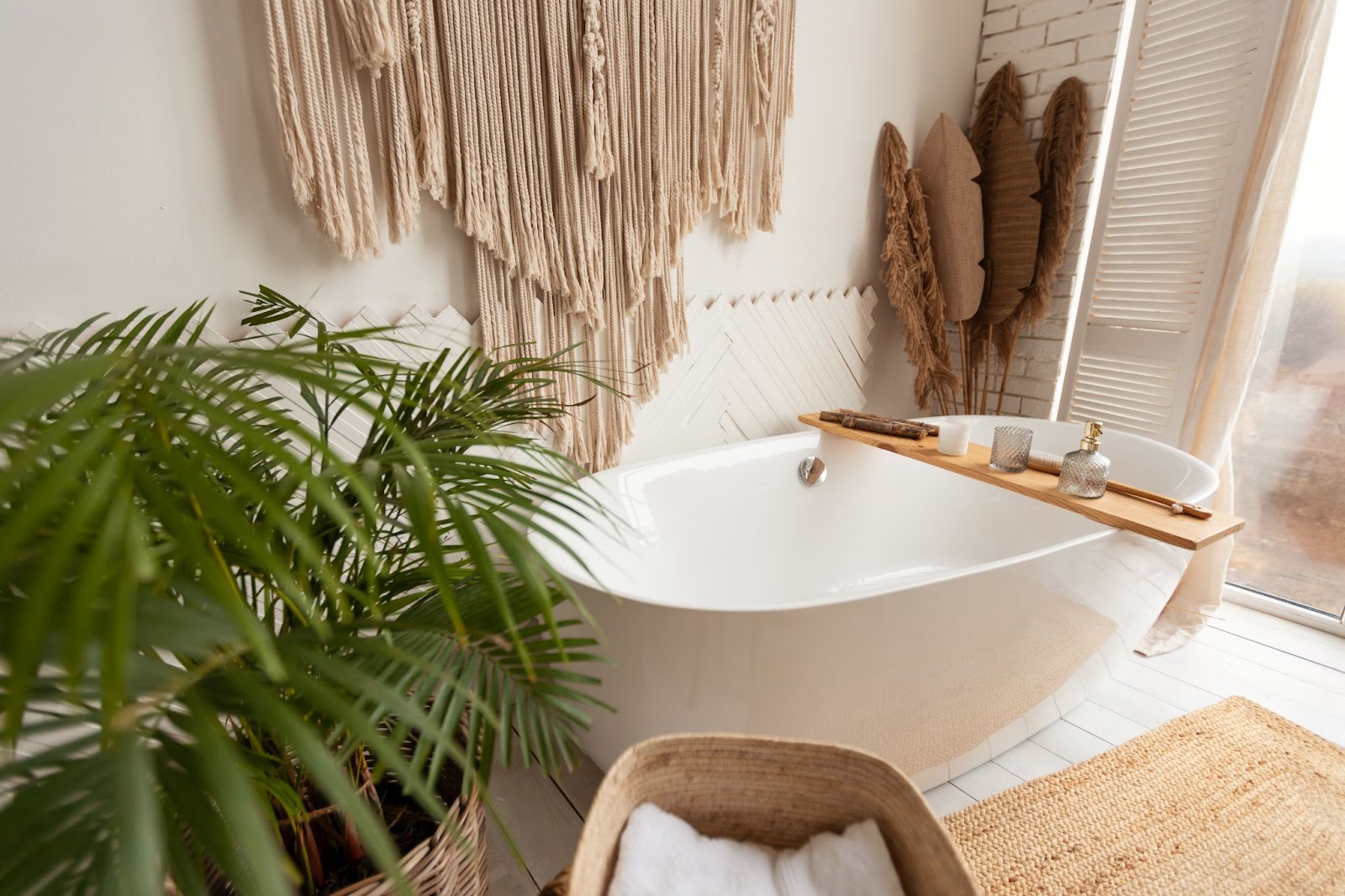 A warm and inviting bathroom interior showcasing a large bathtub, fresh and artificial plants, and rustic hanging decor for a cozy ambiance.