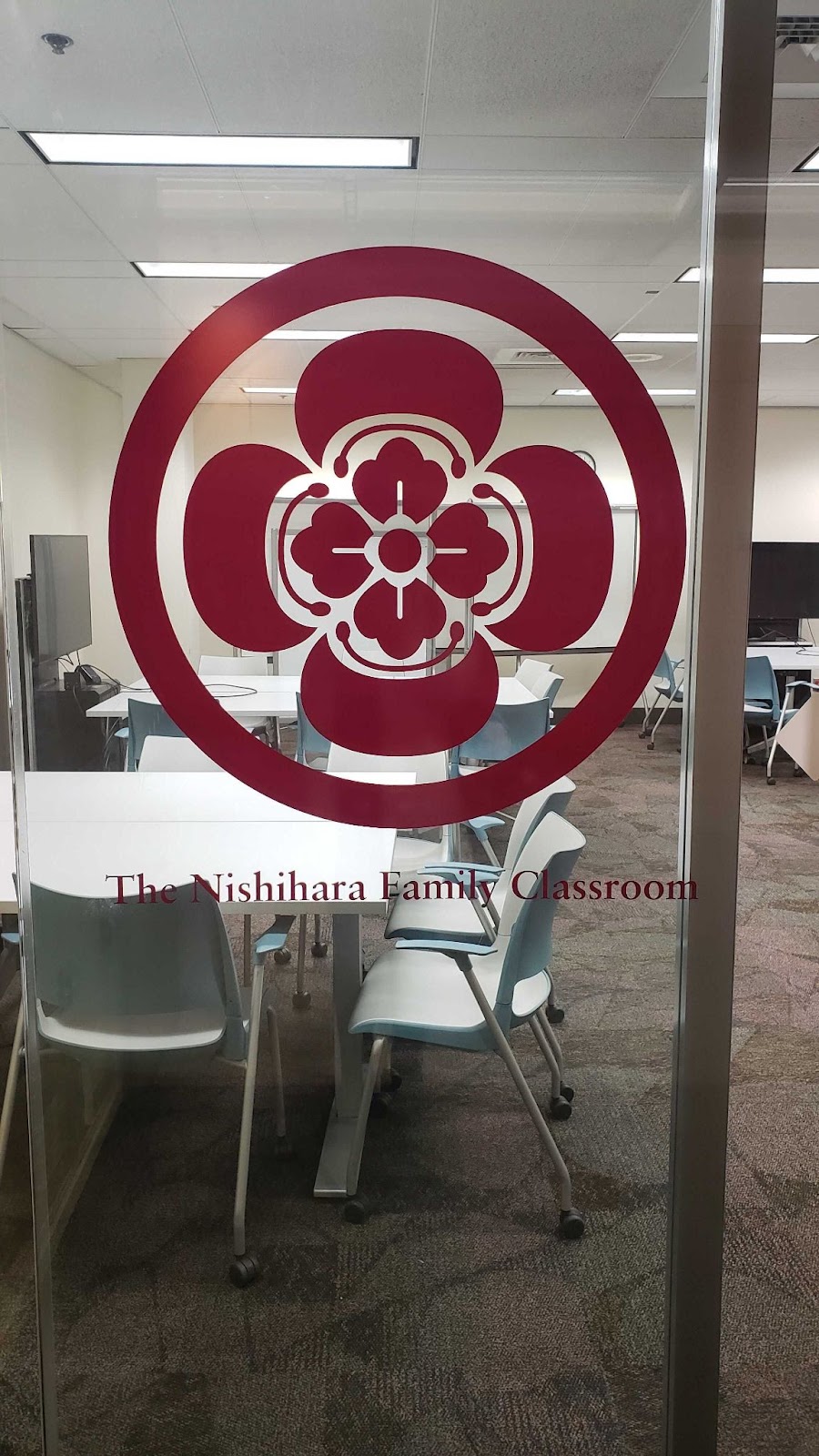 Crest of Nishihara family on glass door of classroom.