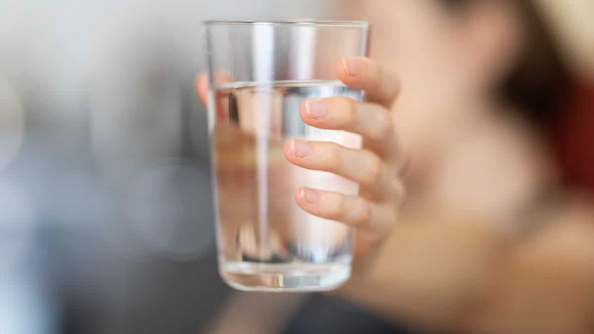 person holding clear drinking glass