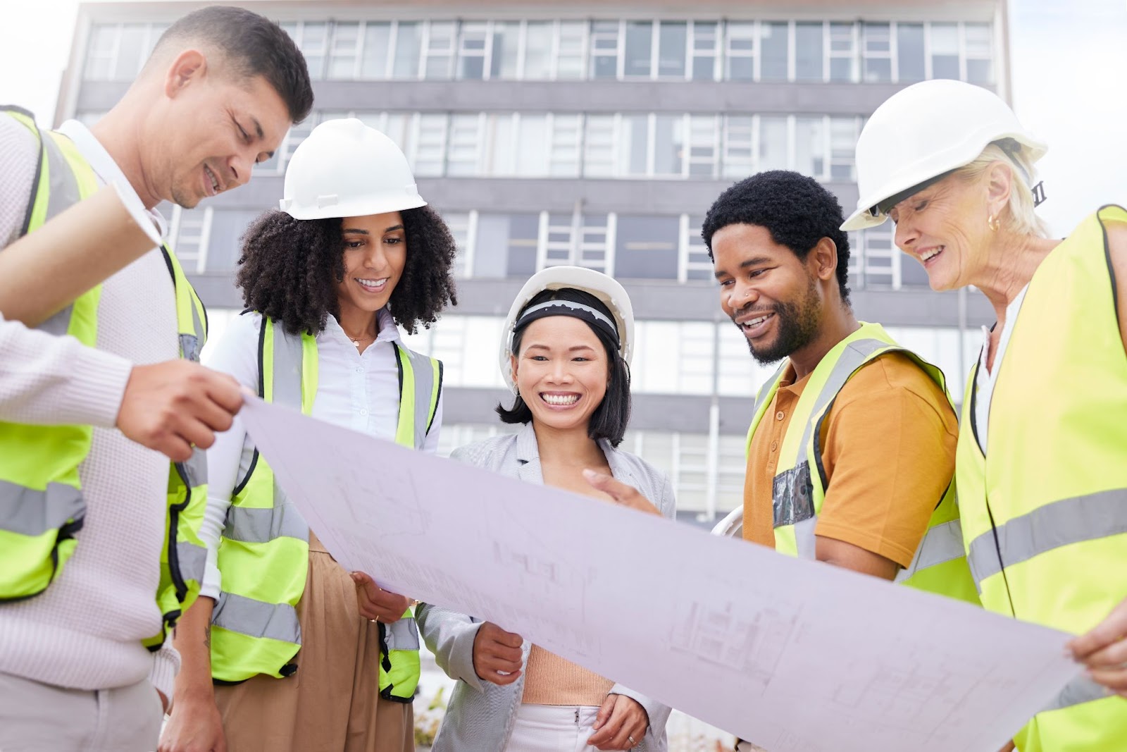  A team of construction builders is looking at the blueprint.