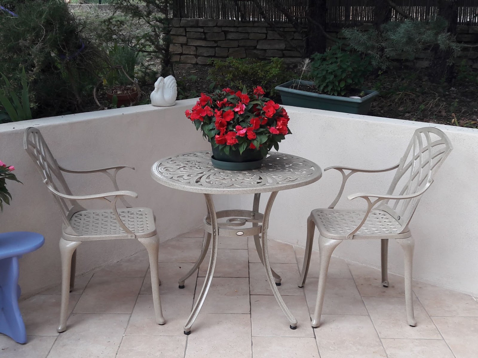 Runder Gartentisch für zwei mit Blumentopf als romantische Dekoration