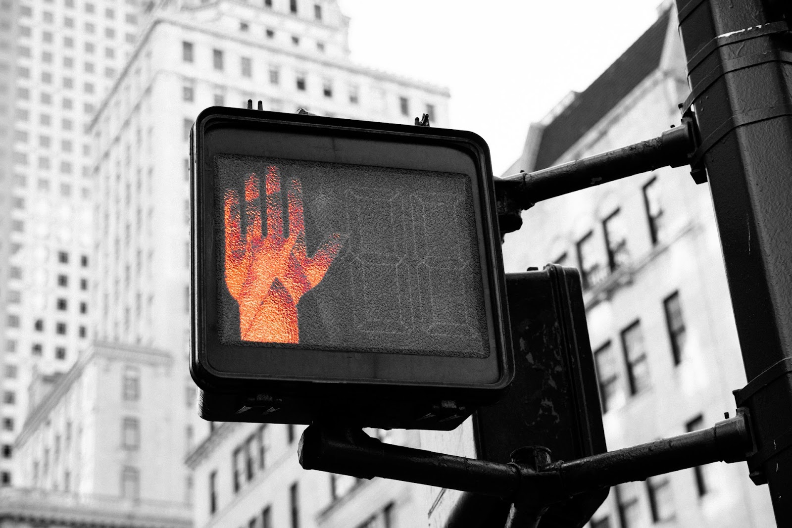 A crosswalk sign with a hand drawn on it