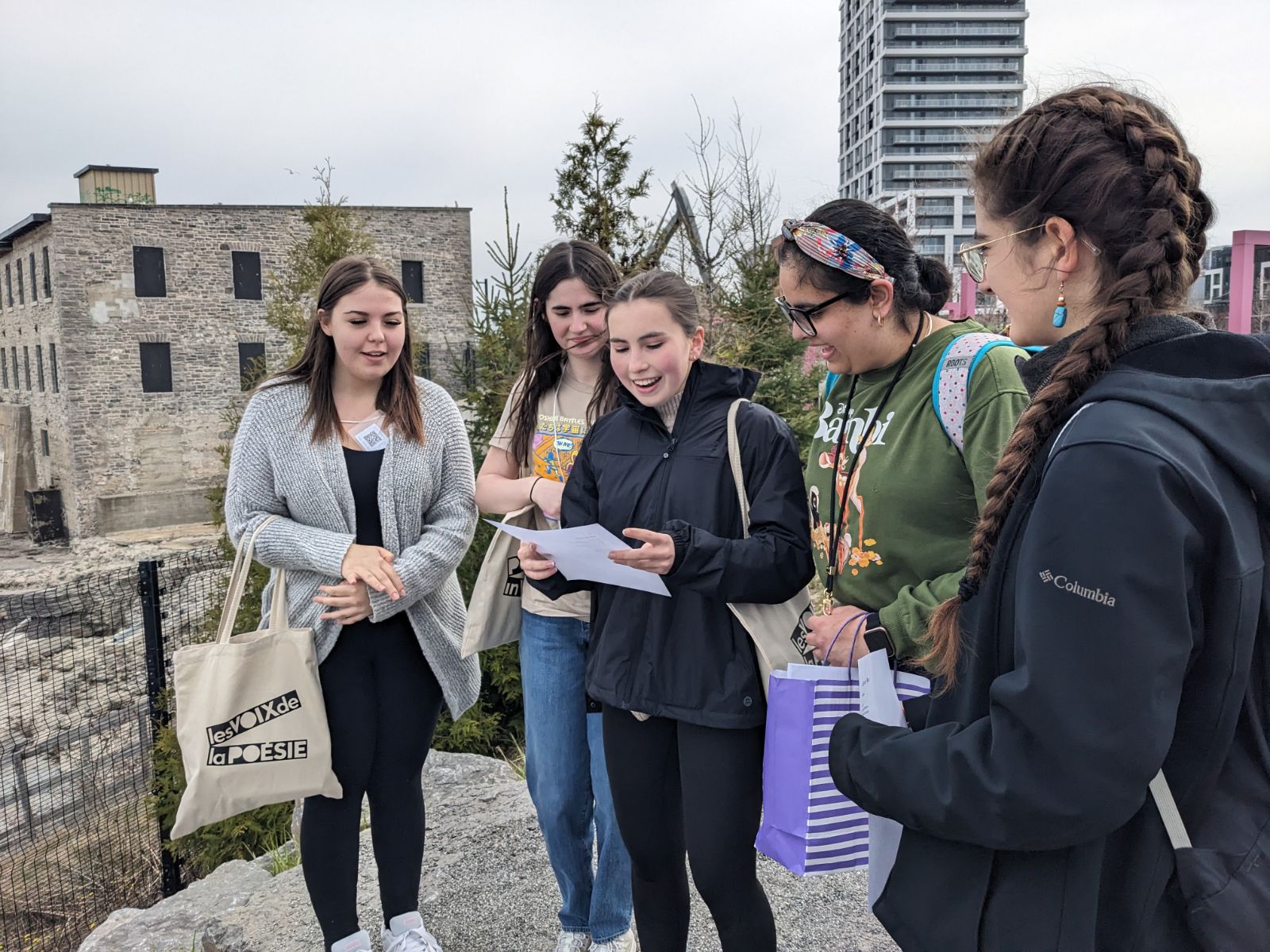 At the Chaudière Falls lookout, students share words with the river. From left to right, Hannah, Maia, Emiliia, Khushi, and Leïla take turns reciting a poem, line by line. 