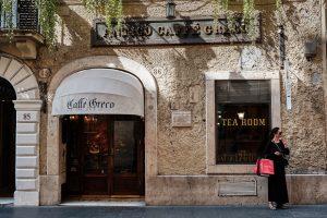 Woman takes break in front of historical coffee house Caffe Greco in downtown Rome.