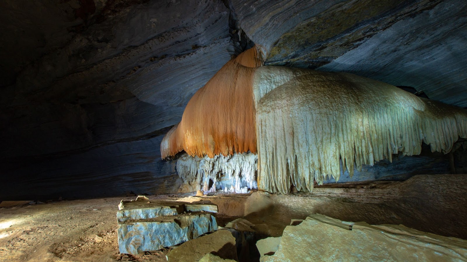 Formações rochosas diversas e com cores leves, sendo formadas na Gruta Lapa Doce, na Chapada Diamantina