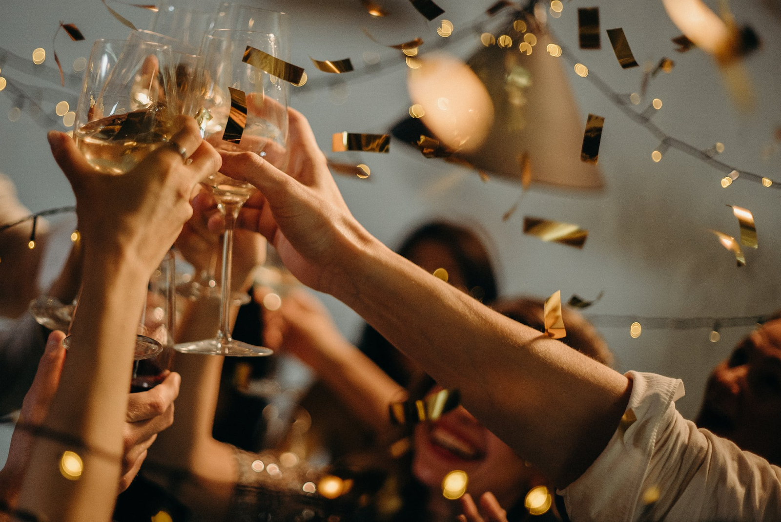 People toasting to new year with champagne glasses.