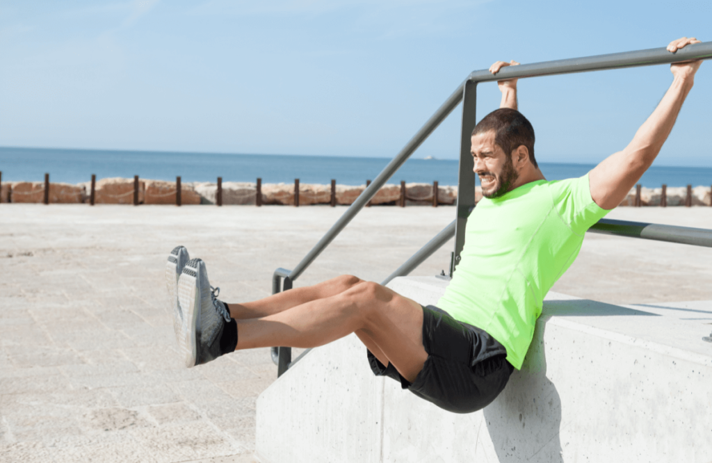 A man performs hanging leg raises