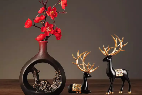 Chinese New Year flower decoration with red artificial blooms on iron branches in a black ceramic vase with traditional Chinese openwork design