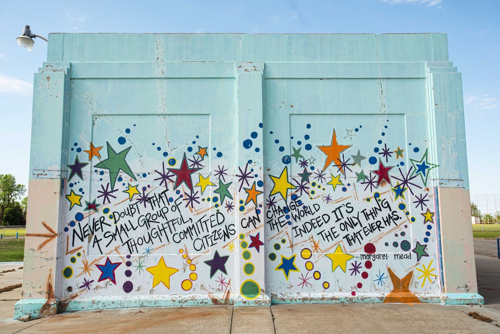 Photo of a mural with colorful stars and text. The text reads, "Never doubt that a small group of thoughtful, committed citizens can change the world indeed it's the only thing that ever has. margaret mead" 