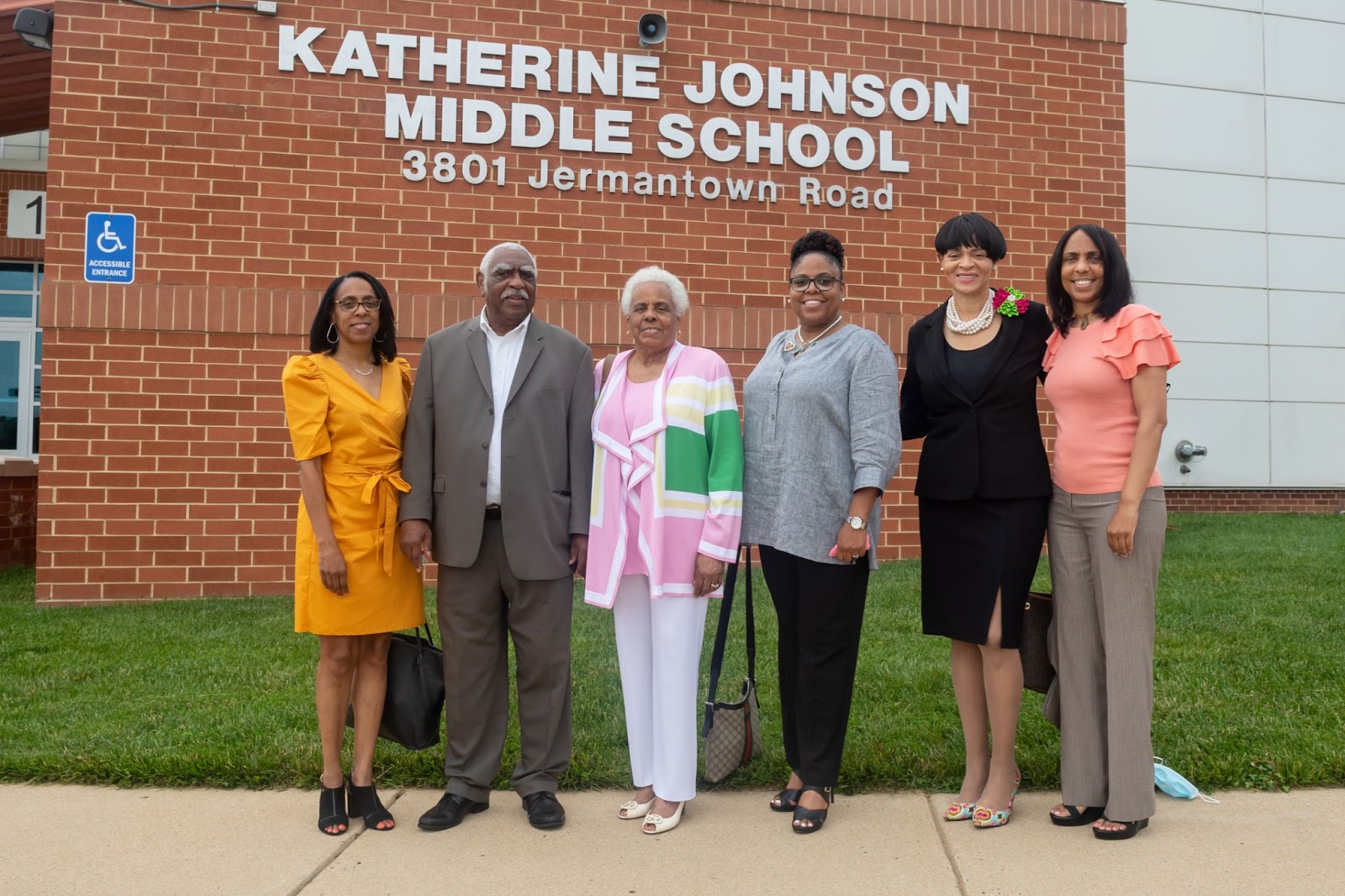 Valerie Johnson and family pose for a photo outside of Johnson Middle School.
