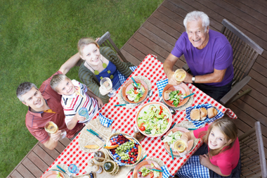 family enjoying dinner at table on composite deck custom built michigan