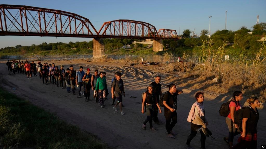 TƯ LIỆU - Di dân vượt sông Rio Grande và tiến vào Mỹ từ Mexico xếp hàng chờ được Cơ quan Hải quan và Bảo vệ Biên giới Hoa Kỳ làm thủ tục, ngày 23 tháng 9 năm 2023, tại Eagle Pass, Texas.