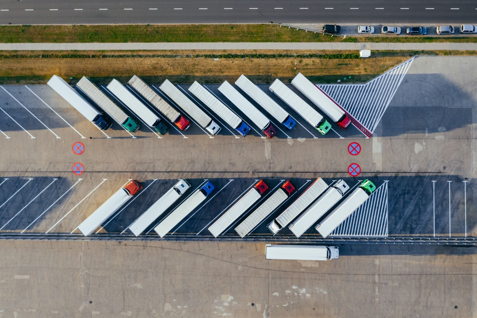 An aerial view of a fleet of semi-trucks in a parking lot