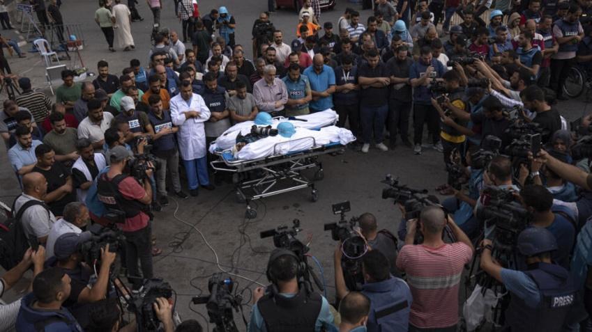 تجمع روزنامه‌نگاران دور اجساد دو خبرنگار فلسطینی که در حمله هوایی اسرائیل در شهر غزه در روز ۱۰ اکتبر ۲۰۲۳ کشته شدند.