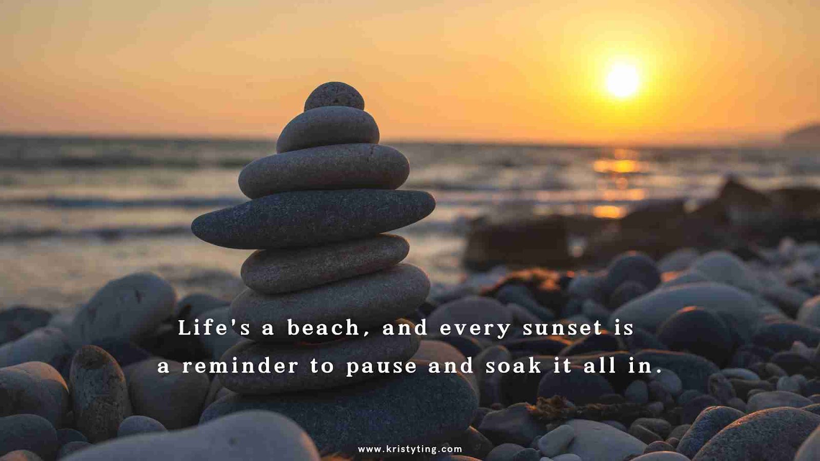 stones balanced in a stack on a beach at dusk.