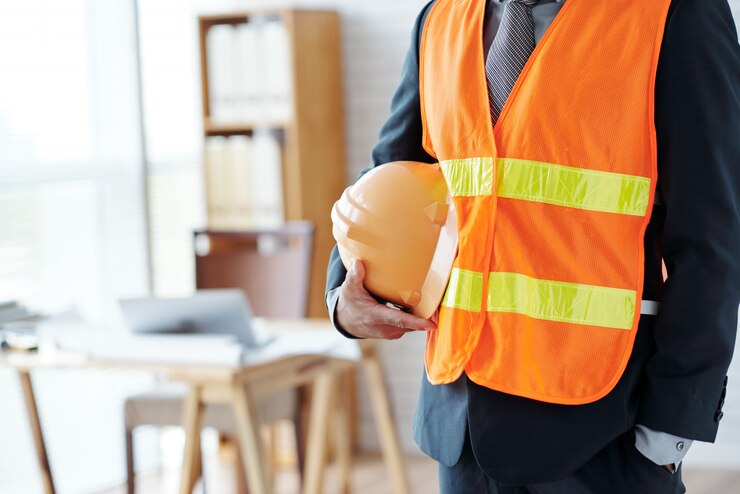 Construction industry executive in safety vest and hardhat.