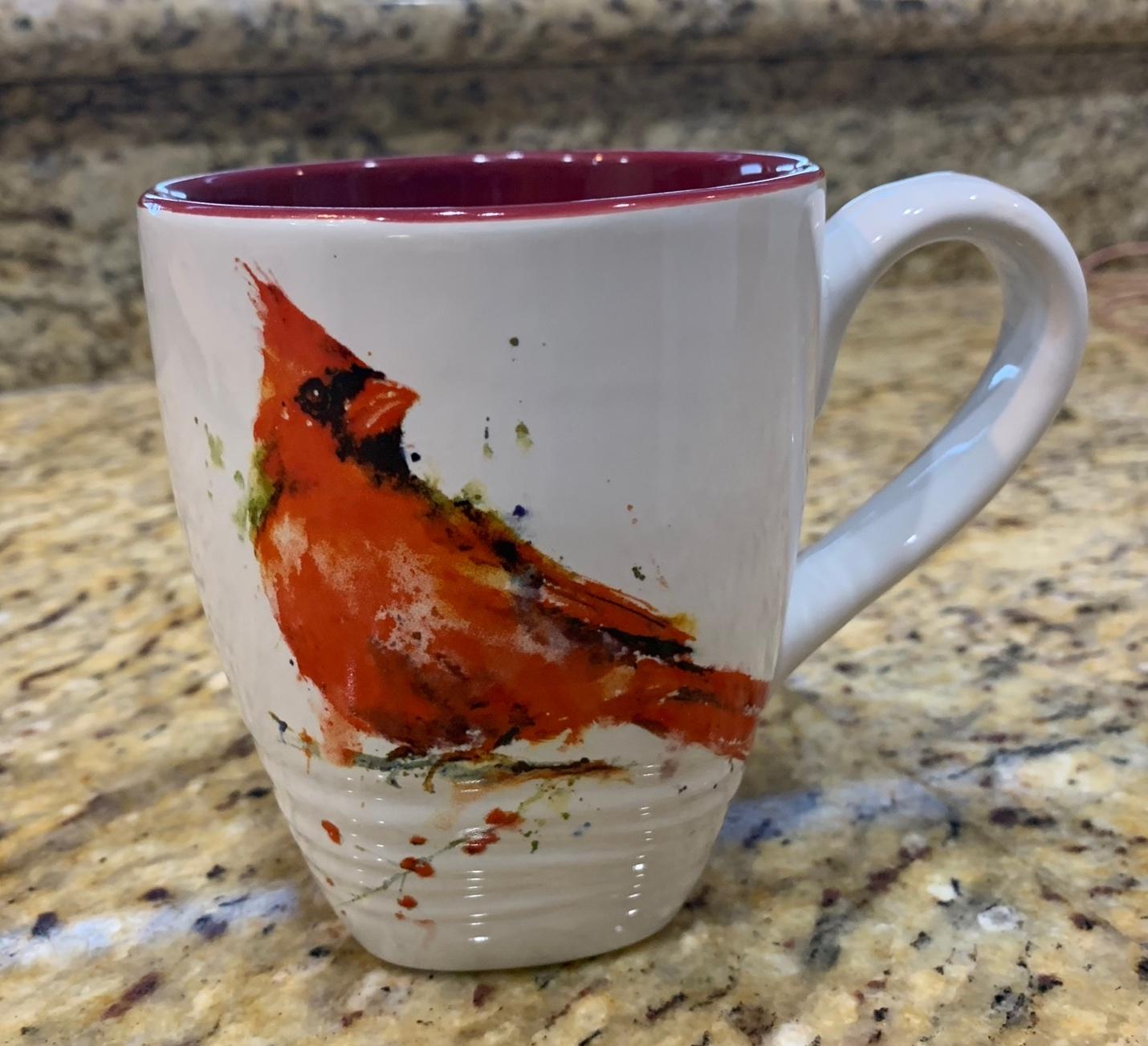 A white and red coffee mug with a bird on it

Description automatically generated