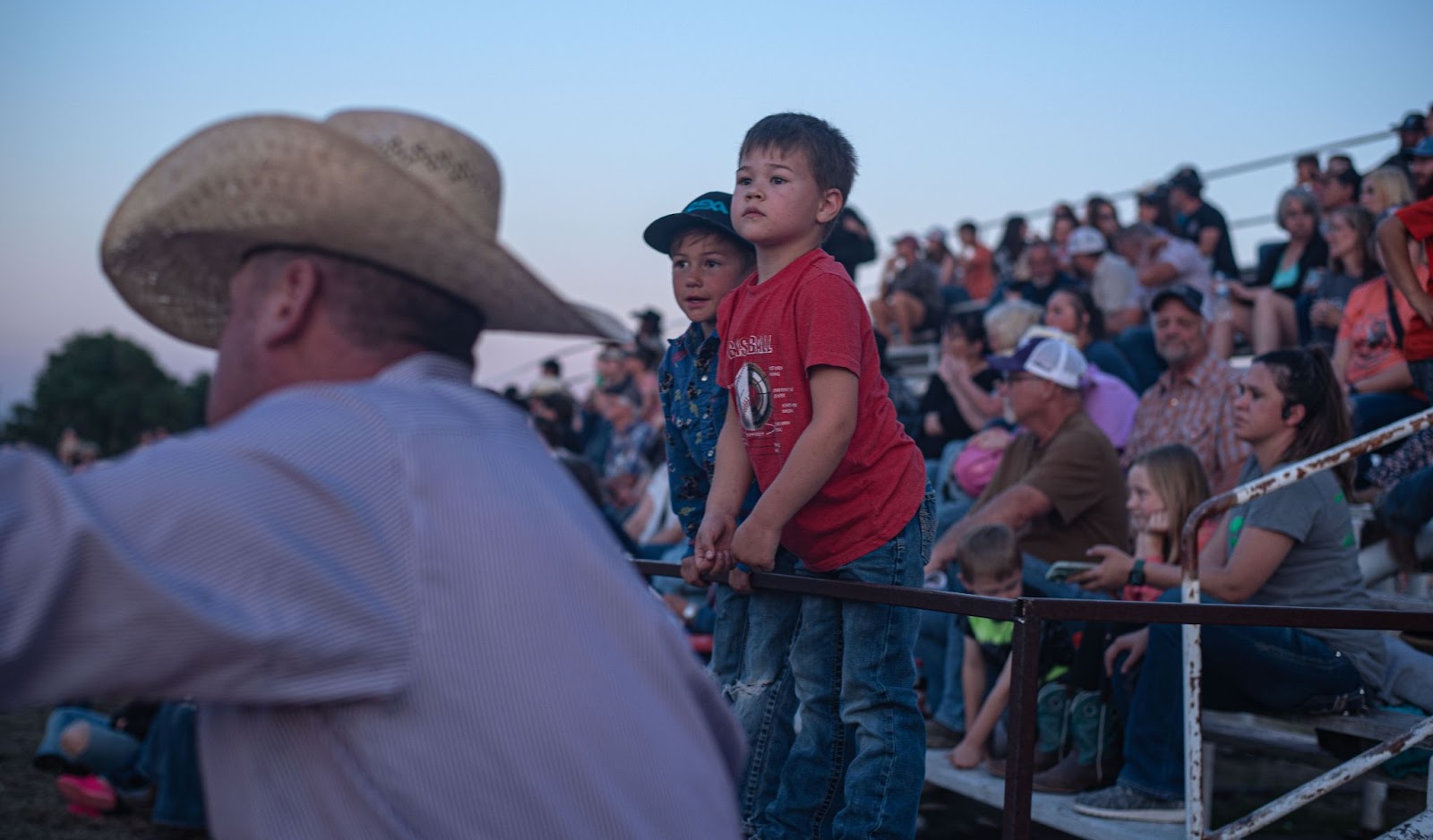 Photo of two children who are entranced as they watch the rodeo 