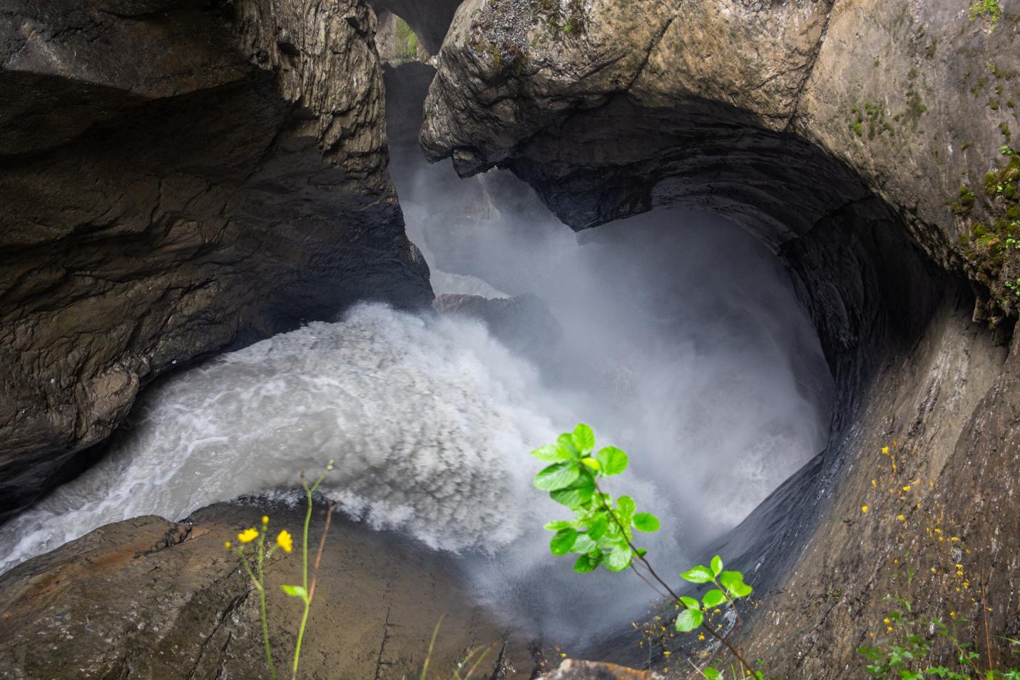 A water flowing through a hole in a rock

Description automatically generated