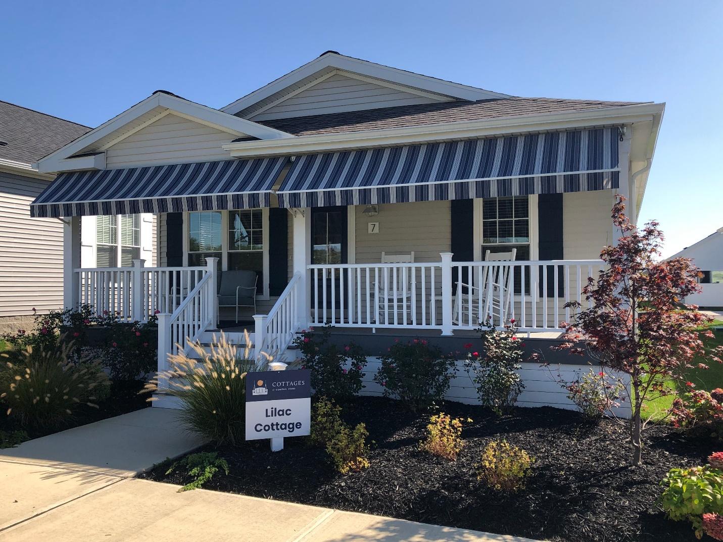 A house with a porch and a sign

Description automatically generated