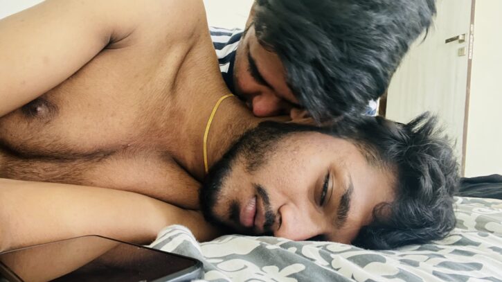 Mr Yuvii  lying shirtless on the bed getting kissed on the neck by gay hookup app 