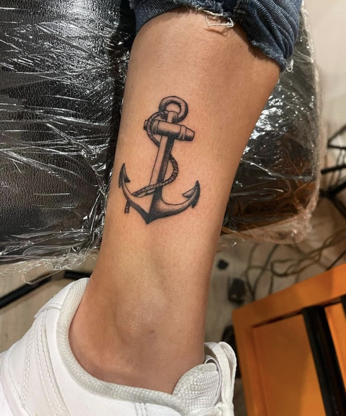 Ship anchor and rope tattoo on ankle in black ink