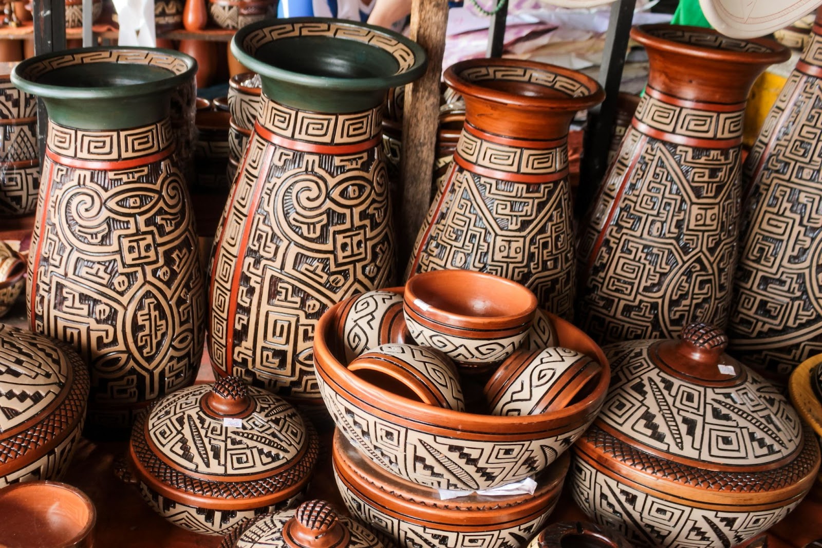 Vasos de cerâmica artesanais, com traços indígenas em relevo.