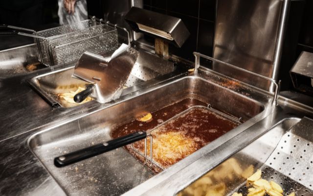 A commercial deep fryer cooking delicious food.