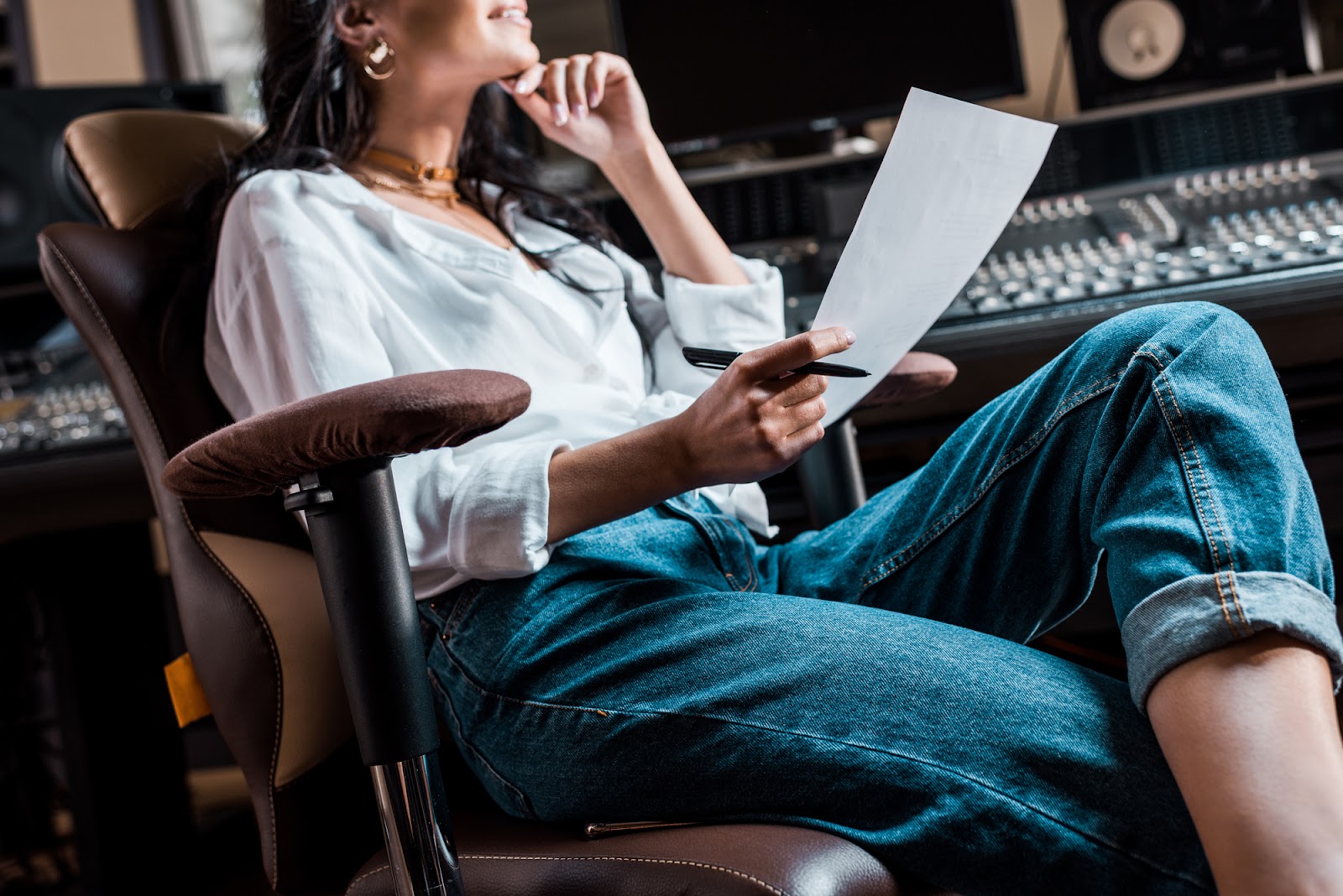 A woman sitting comfortably on a swivel chair while writing