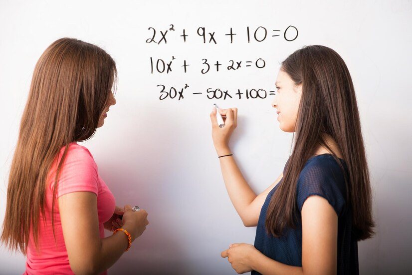 cute young high school students solving some algebra equations white board