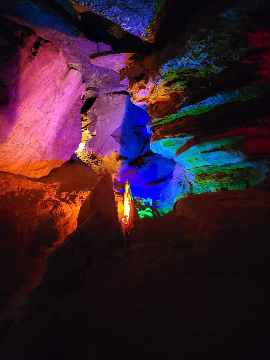 A cave with colorful lightsDescription automatically generated