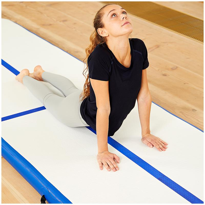 A fit woman doing supine spinal twist on an airtrack mat