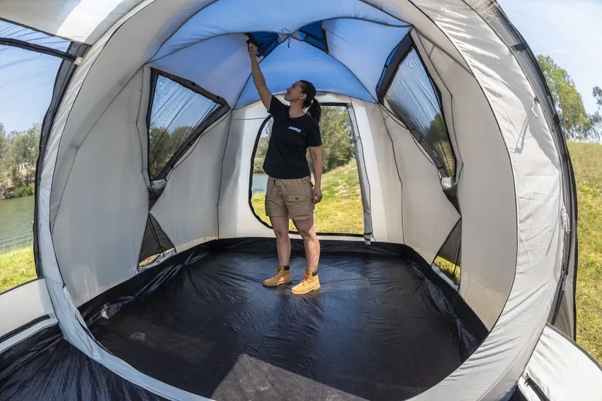 An adult in a dome-shaped trampoline tent