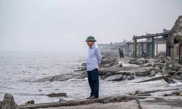 A person standing on a rocky beach

Description automatically generated